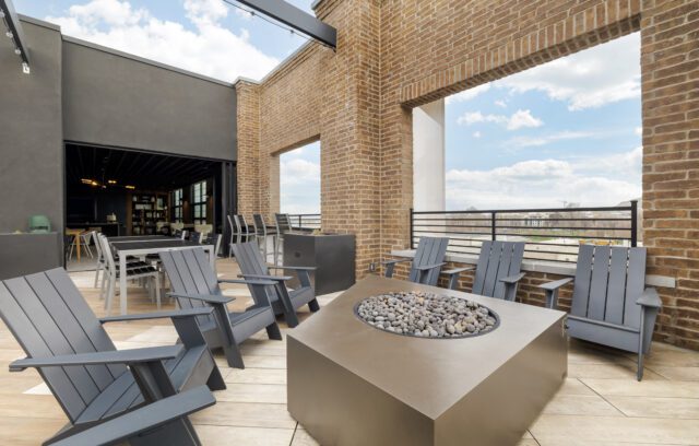 Rooftop lounge with firepit and view of indoor lounge area at The Register