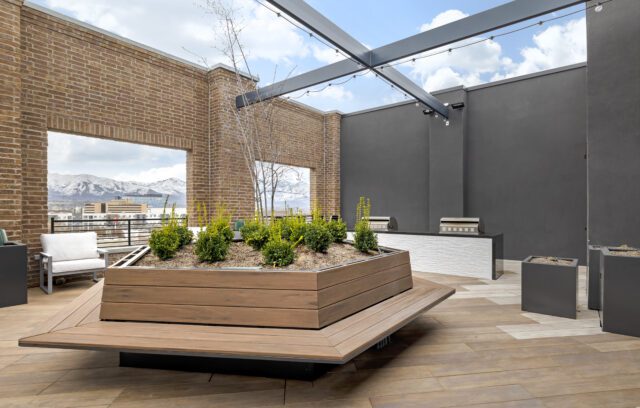 Rooftop lounge with planter gardens, benches, and BBQs at The Register