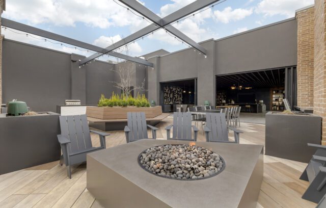 Open top rooftop lounge with platers and fire pit at The Register